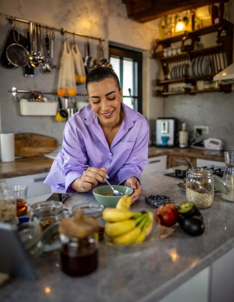 woman preparing healthy meal in kitchen while trying to lose belly fat with diet and exercise