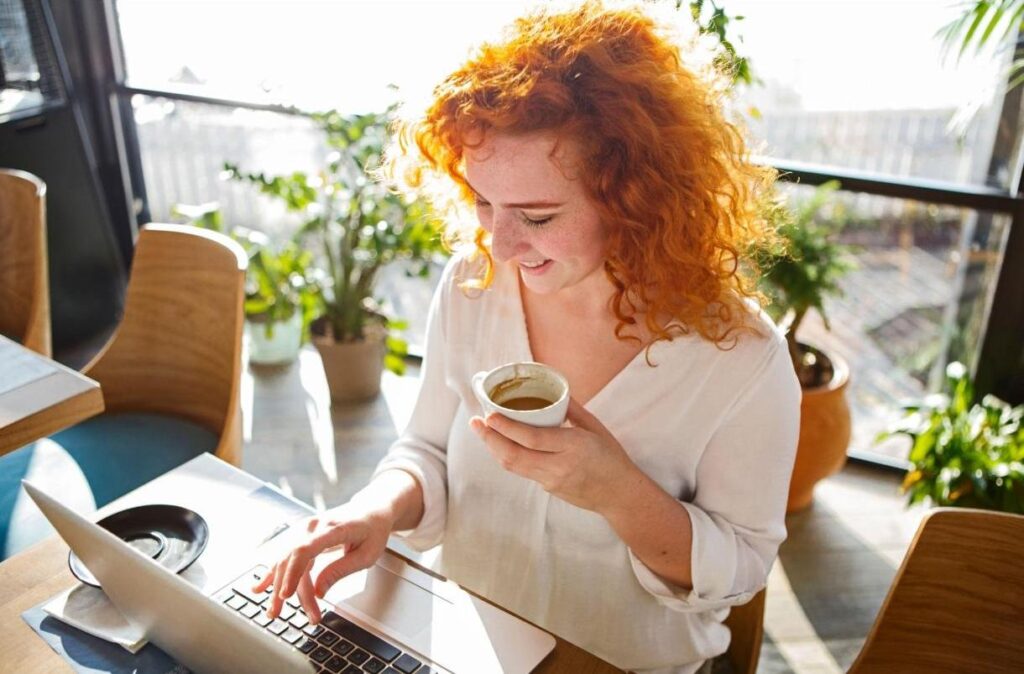 Woman researching supplement safety while drinking coffee at home